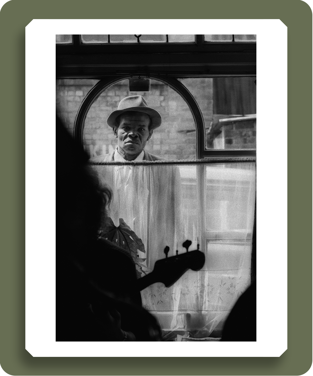 d3011201 : A man, seemingly excluded by poverty or race / colour, longingly looking into a pub through the window. Brixton, London, November 1977 -  Credit: Robert Golden / TopFoto 