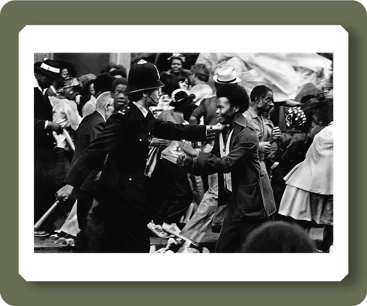 pd3011258: At the 1976 Notting Hill Carnival the police surrounded the festivities and, to everyone's surprise, they attacked the crowd. Here is one moment when a strange confrontation took place as they are surrounded by the chaos. August 1976  - Credit: Robert Golden / TopFoto 