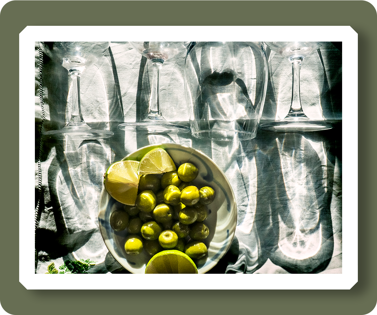 pd3019325 : olives in bowl amongst wine glass shadows - Credit: Robert Golden / TopFoto